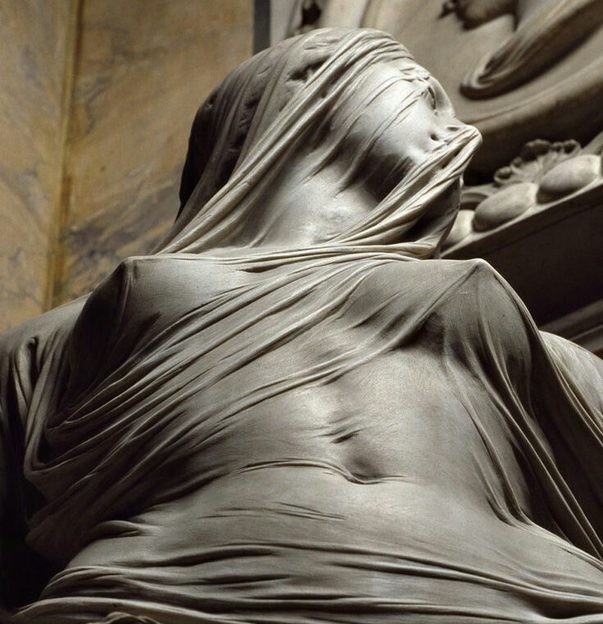 A veiled sculpted figure in soft light